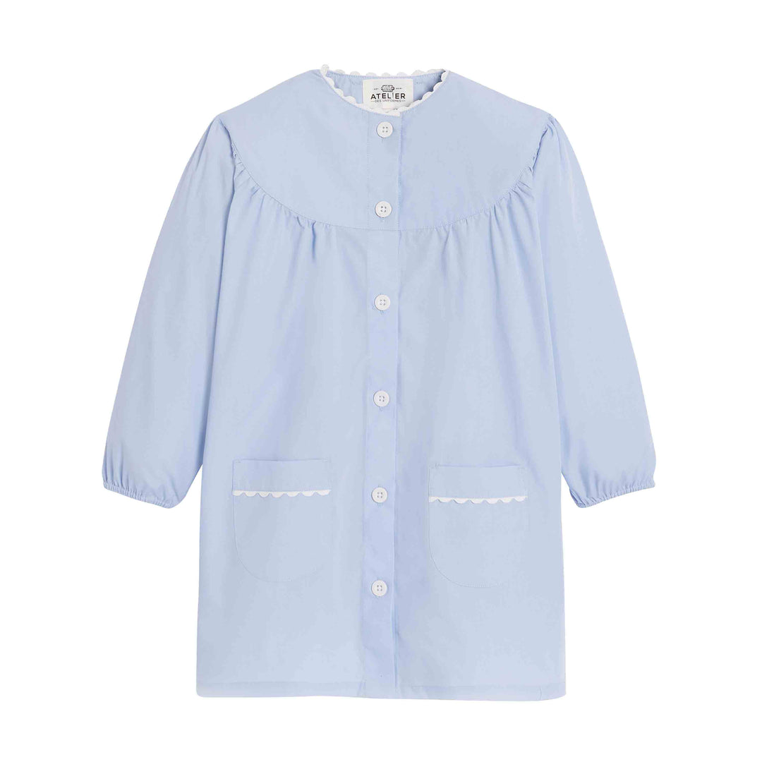 Fille's school apron in sky blue by Jeanne, featuring a front pocket and adjustable straps, ideal for art and crafts.