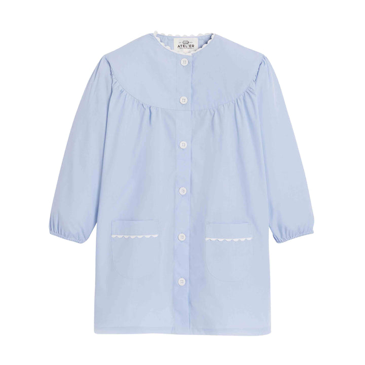 Fille's school apron in sky blue by Jeanne, featuring a front pocket and adjustable straps, ideal for art and crafts.